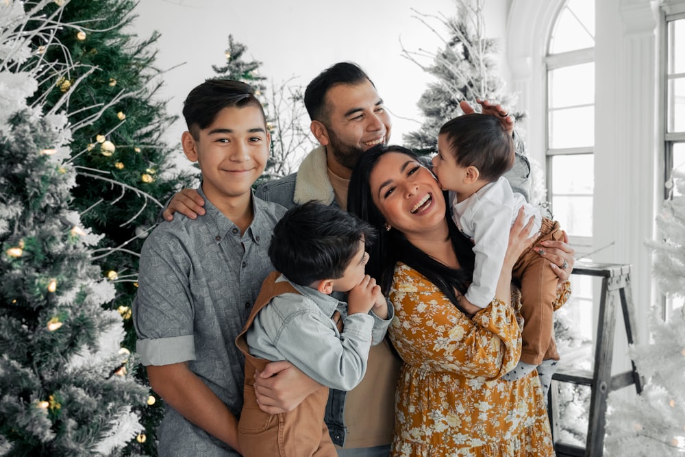 a group of people standing in front of a christmas tree