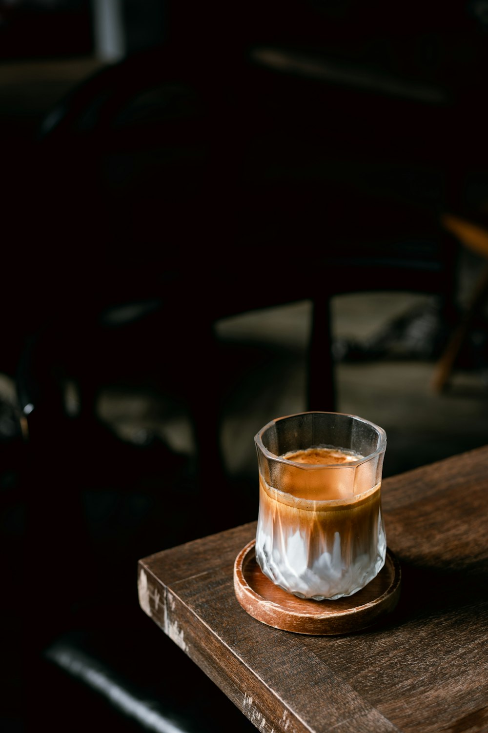 a glass of liquid sitting on top of a wooden table