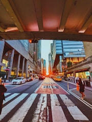 A filmmaker directing a dramatic scene on a bustling city street at sunset.
