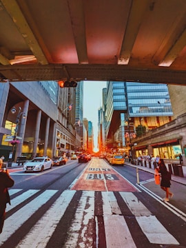 A filmmaker directing a dramatic scene on a bustling city street at sunset.