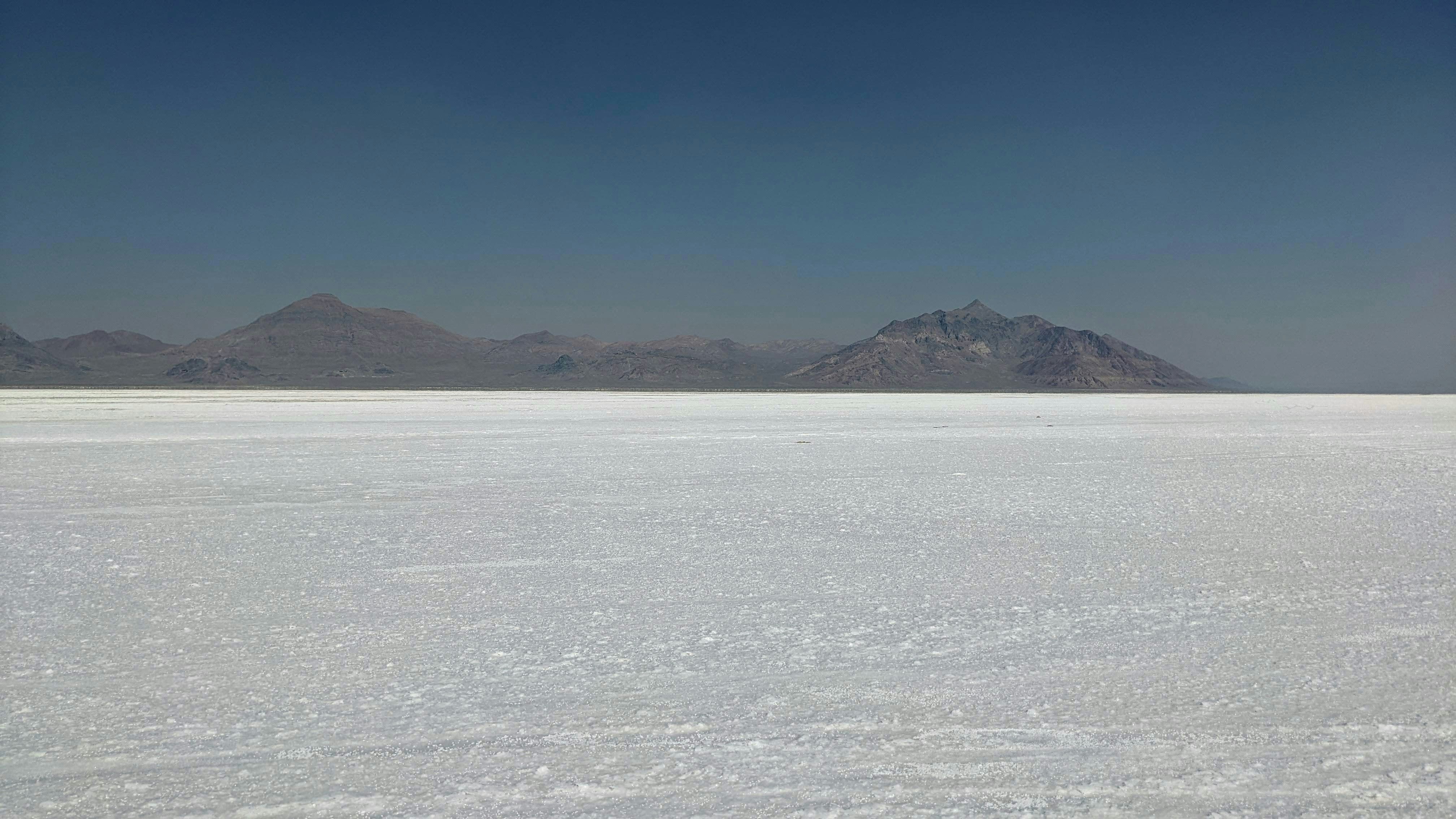a large expanse of snow with mountains in the background