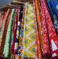 a bunch of different colored ties hanging on a rack