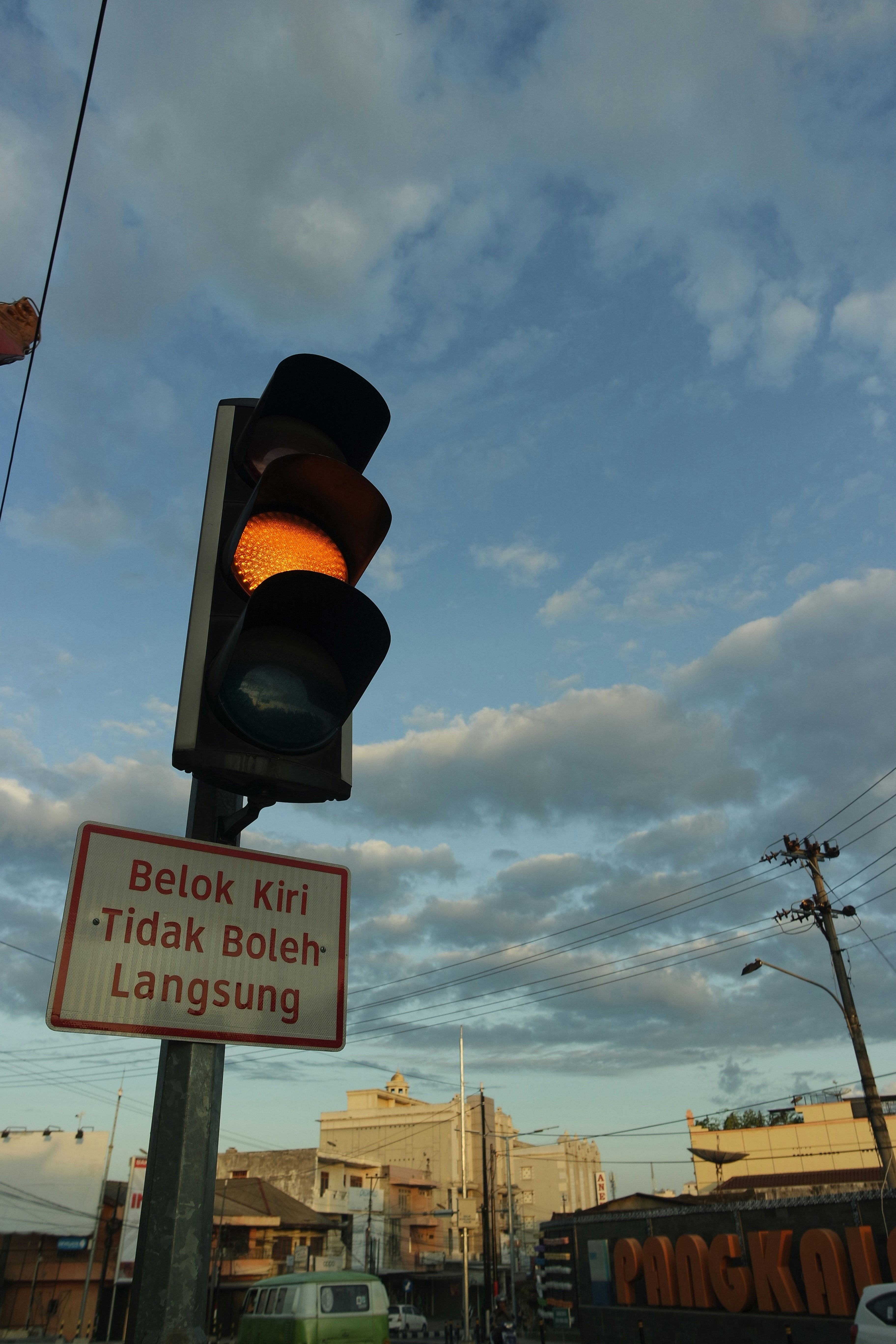 lampu lalu lintas dengan rambu jalan di bawahnya
