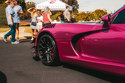 a pink sports car parked in a parking lot