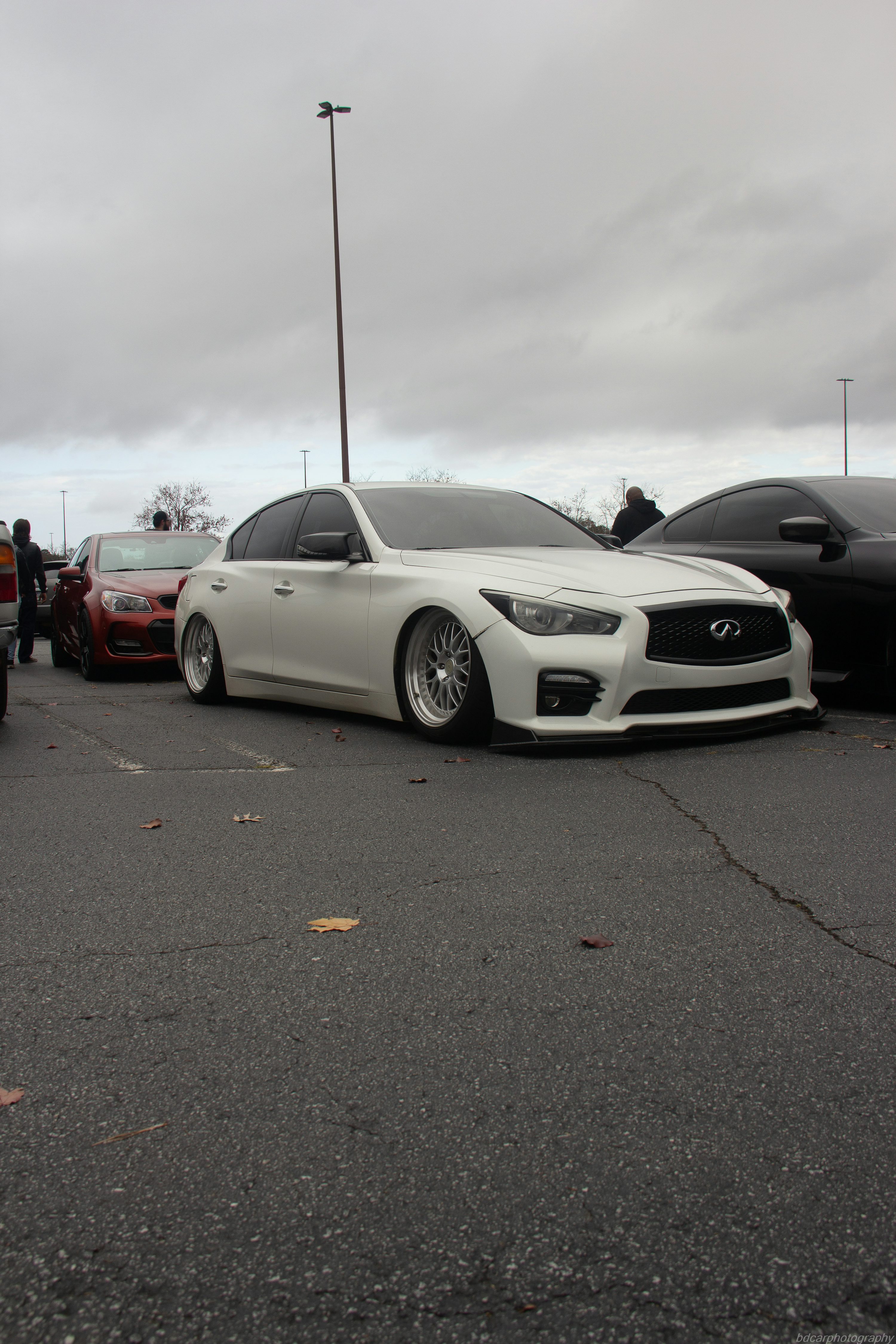 a white car parked in a parking lot next to other cars