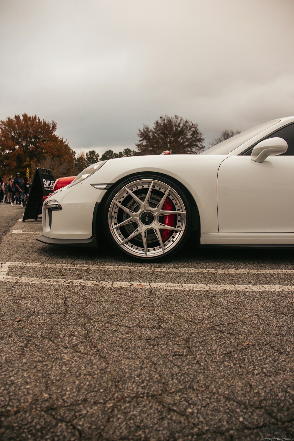 a white sports car parked in a parking lot