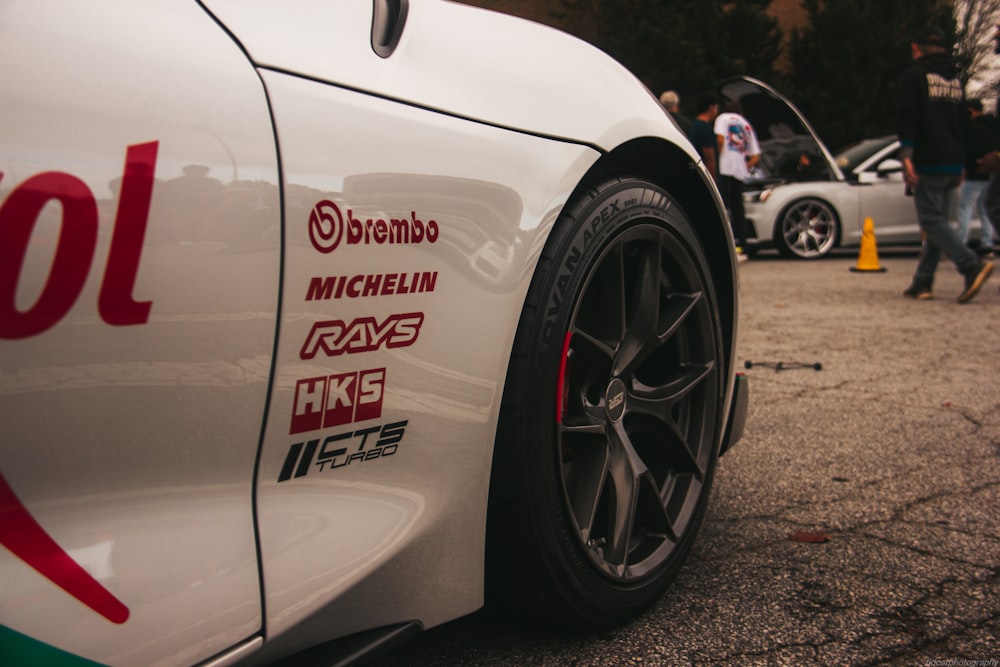 a close up of a white sports car on a street