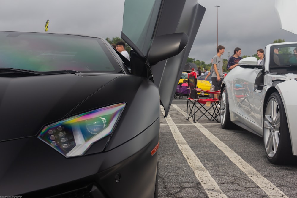 a group of people standing around a white sports car