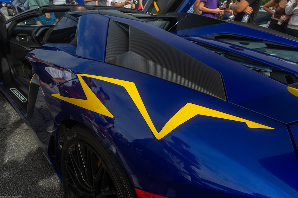 a blue sports car with a yellow arrow painted on it