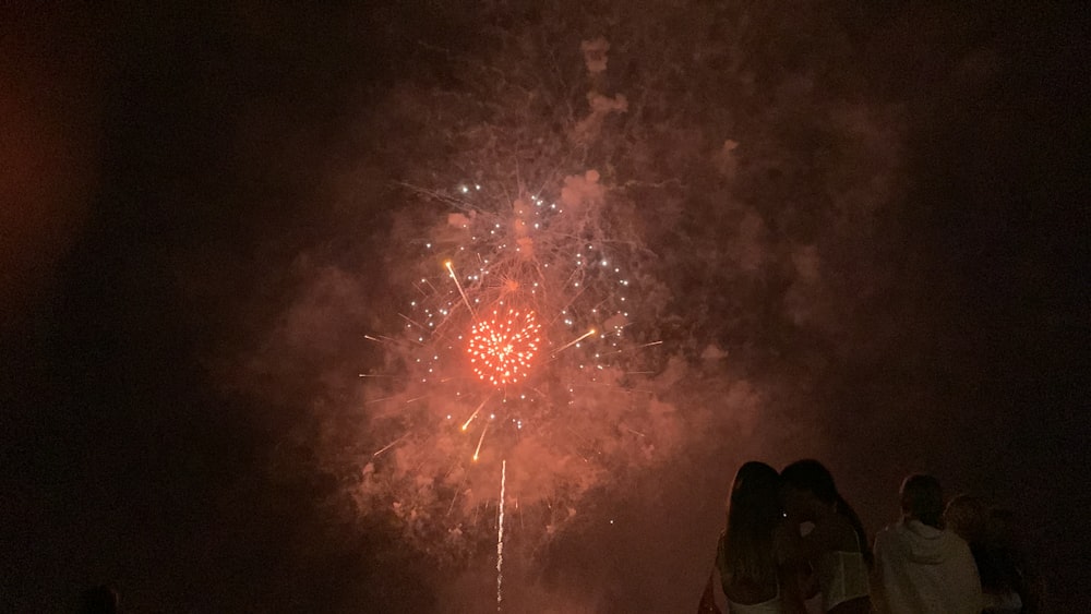 a group of people standing around a firework display