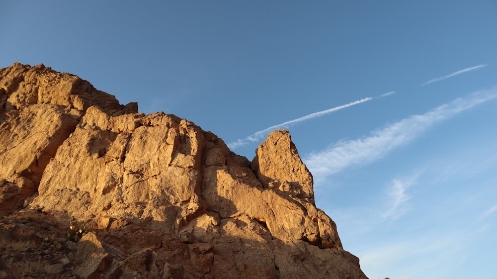 a rock formation with a contrail in the sky