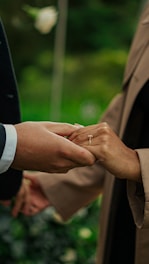 a close up of two people holding hands