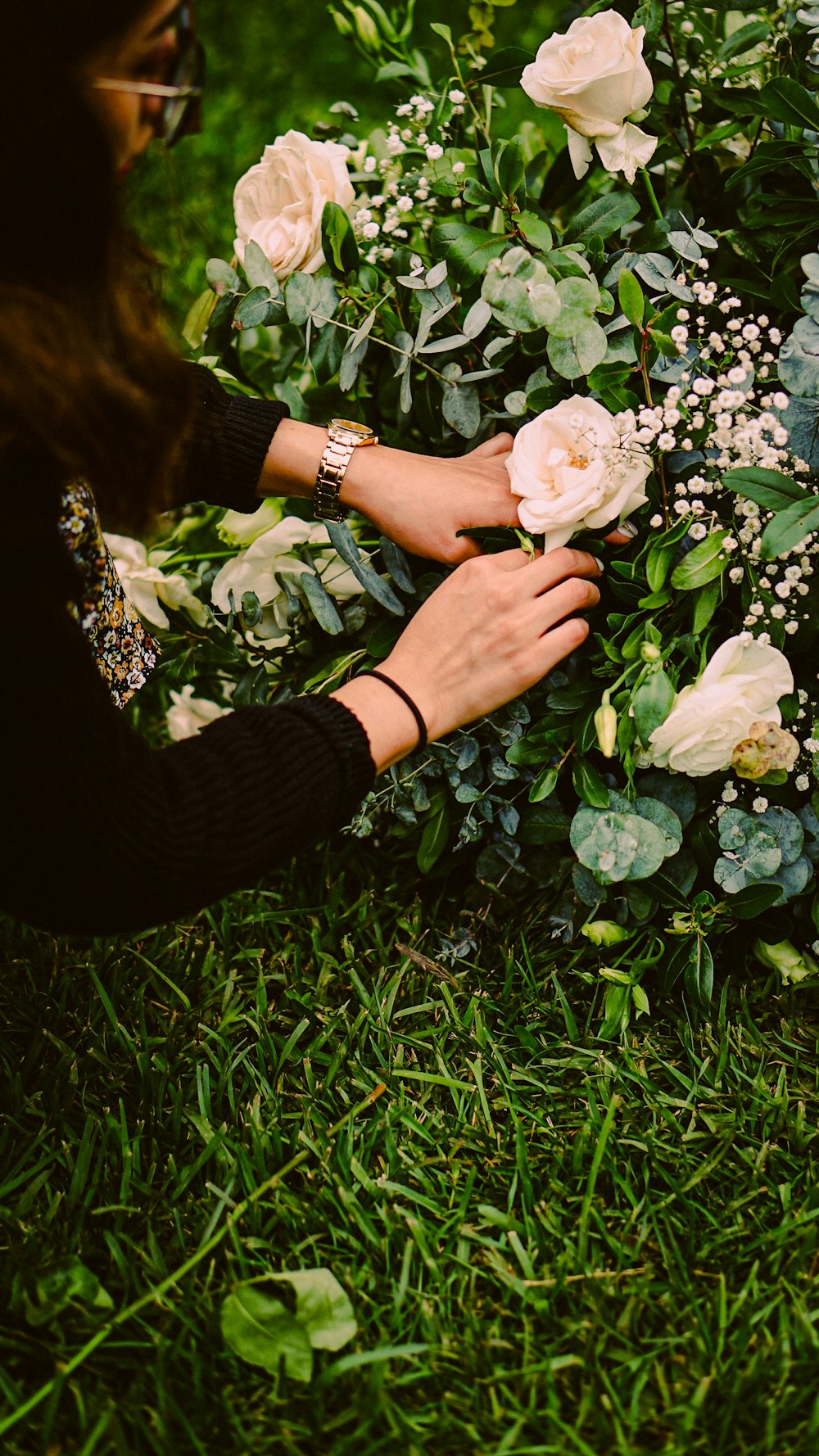 a woman is arranging flowers in the grass