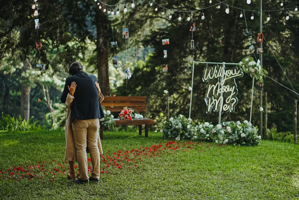 a man and a woman standing in front of a wooden bench