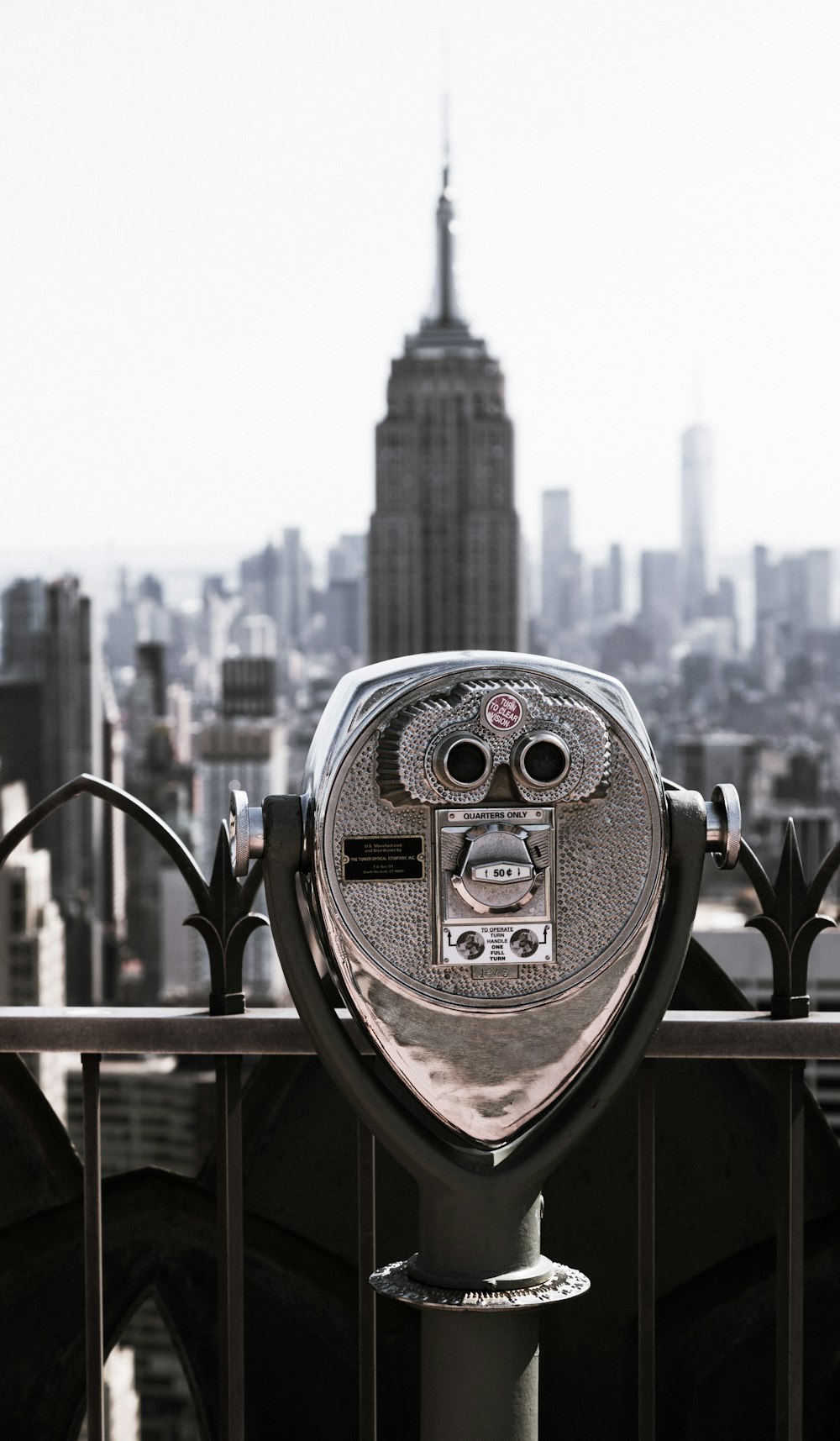 a coin operated parking meter overlooking a city skyline