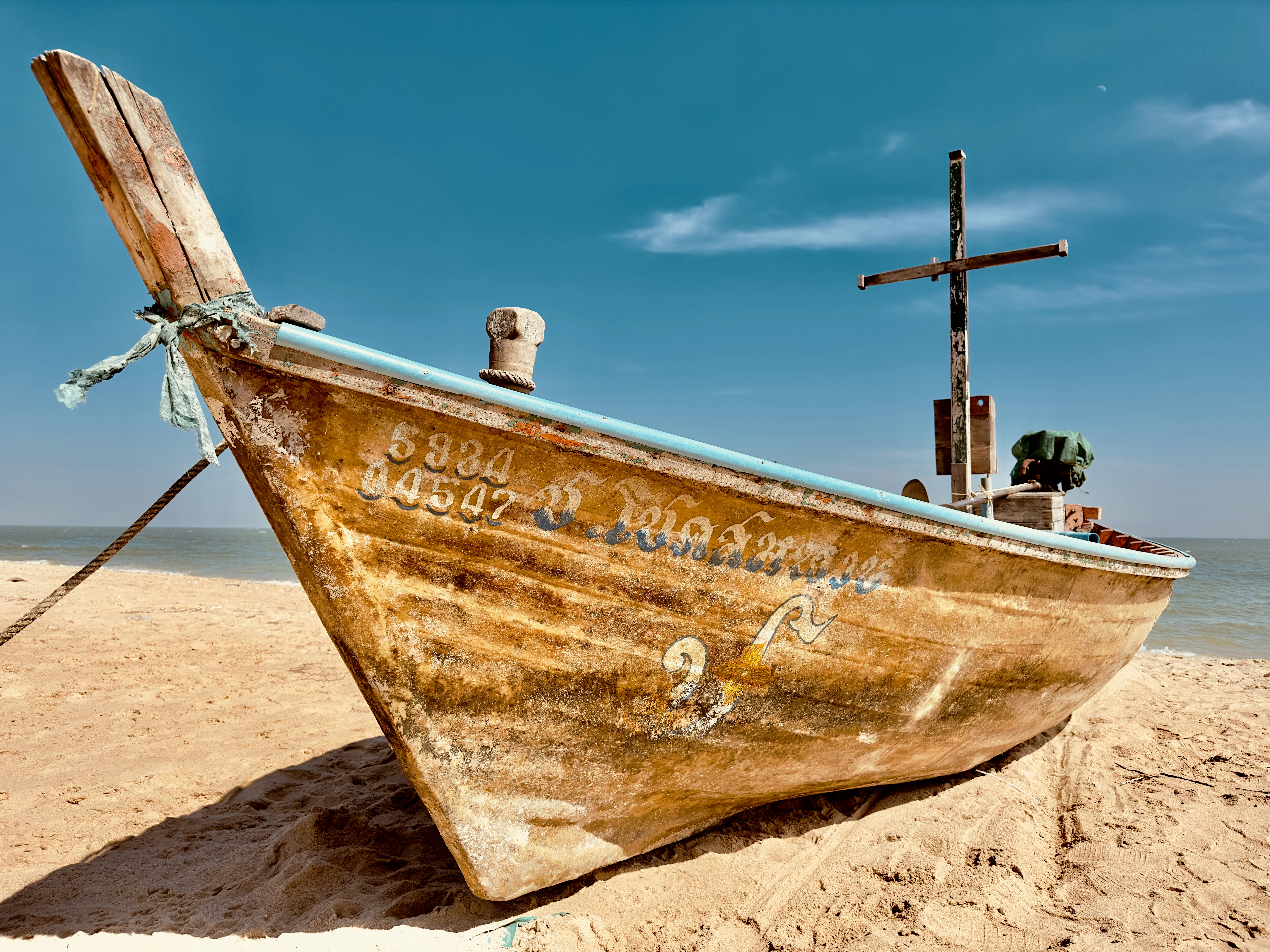 a wooden boat sitting on top of a sandy beach