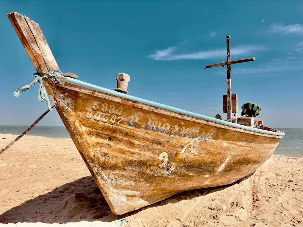 a wooden boat sitting on top of a sandy beach