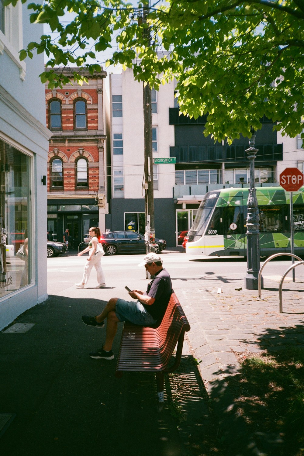 a man sitting on a bench on a city street
