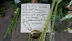 A close-up of a thoughtful message written on a condolence card resting on a wooden table.