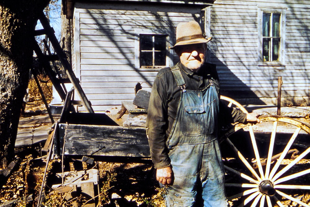 a man standing next to a wooden wagon