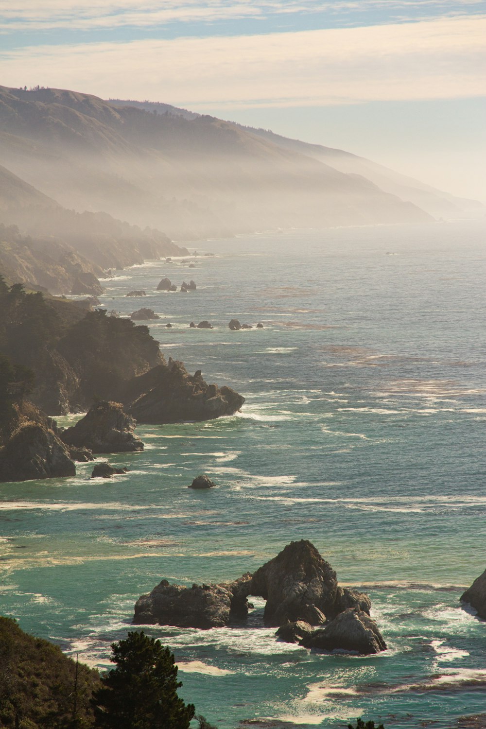 a scenic view of the ocean with a mountain in the background