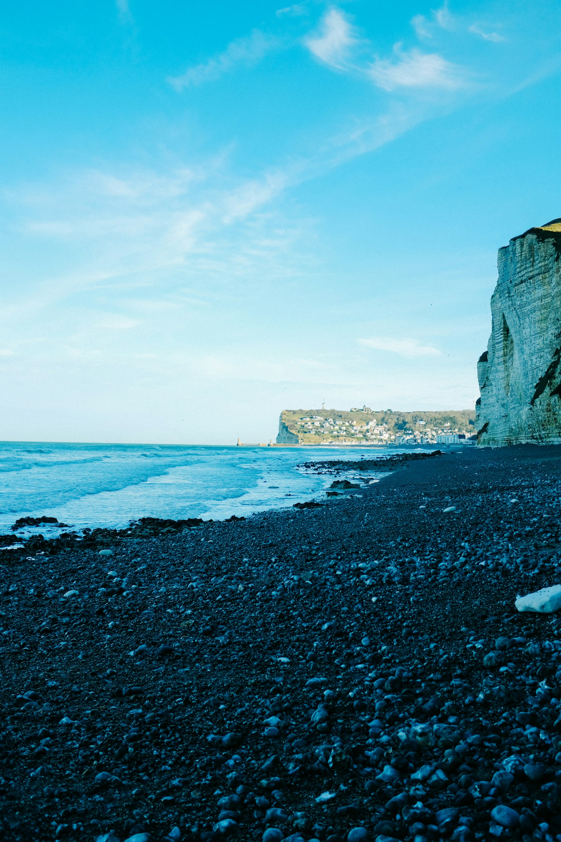 a person standing on a rocky beach next to the ocean