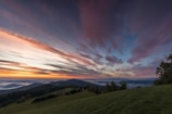 A serene landscape with a sunrise over rolling hills.