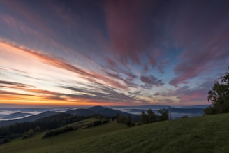 A serene landscape from one of Carole's experiential travel journeys, showing a sunrise over rolling hills.
