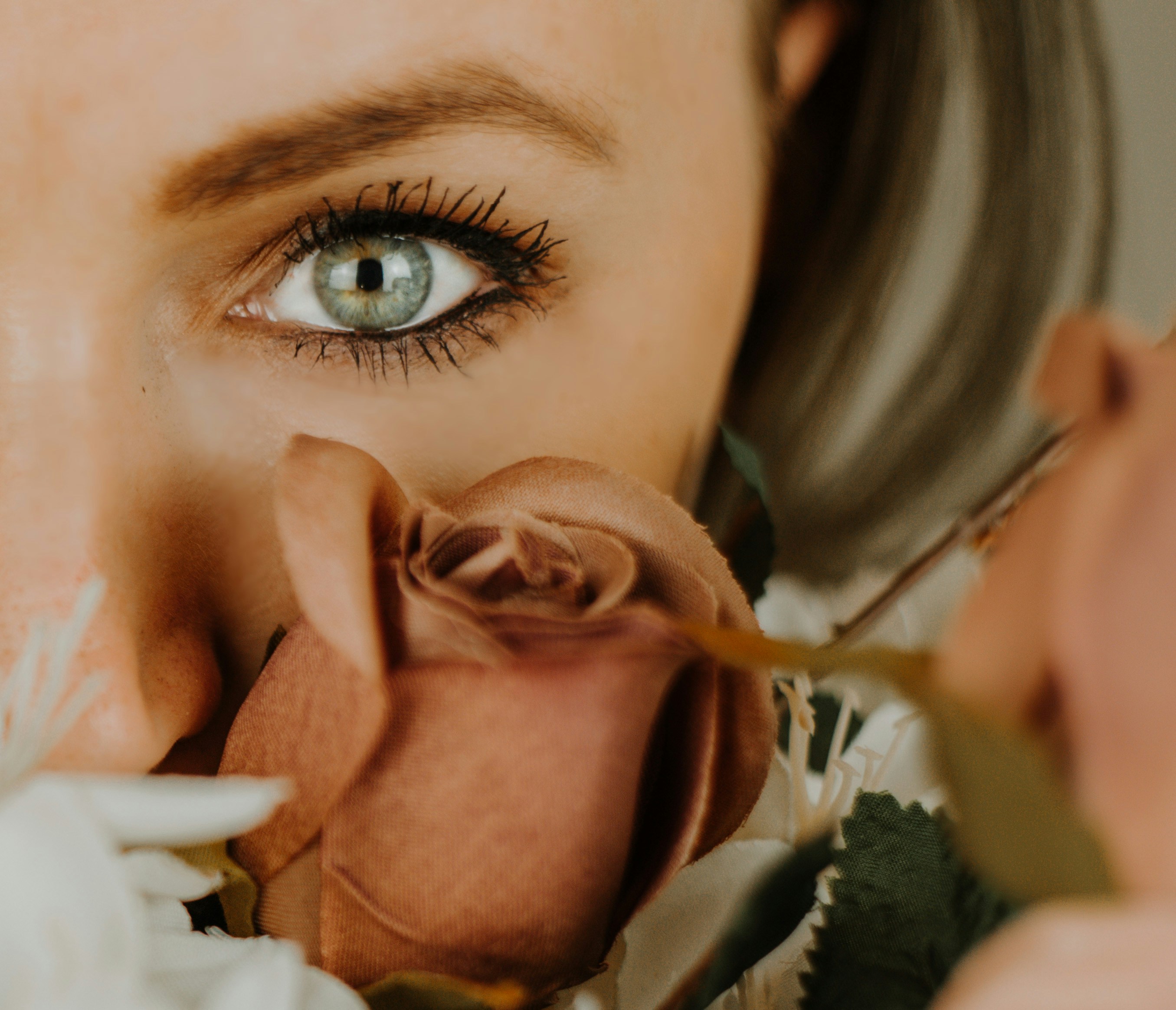a close up of a woman's face with a flower in front of her