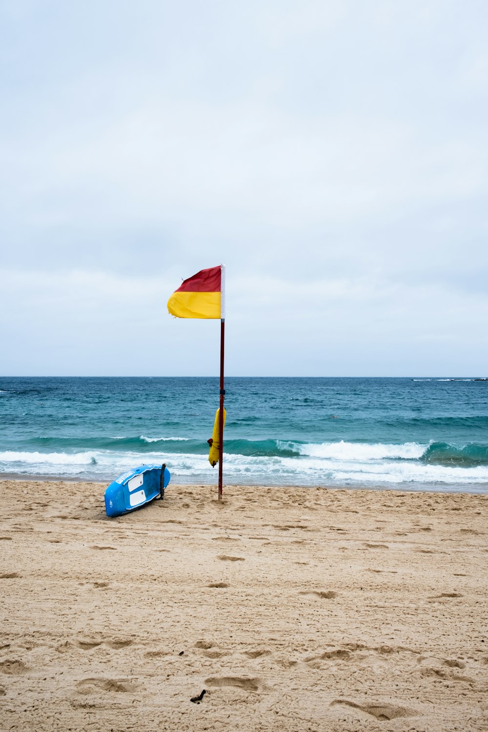 a flag on a beach next to the ocean