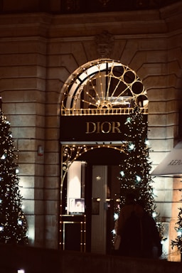 Elegant storefront of deivia extra with dark black and gold accents at dusk.