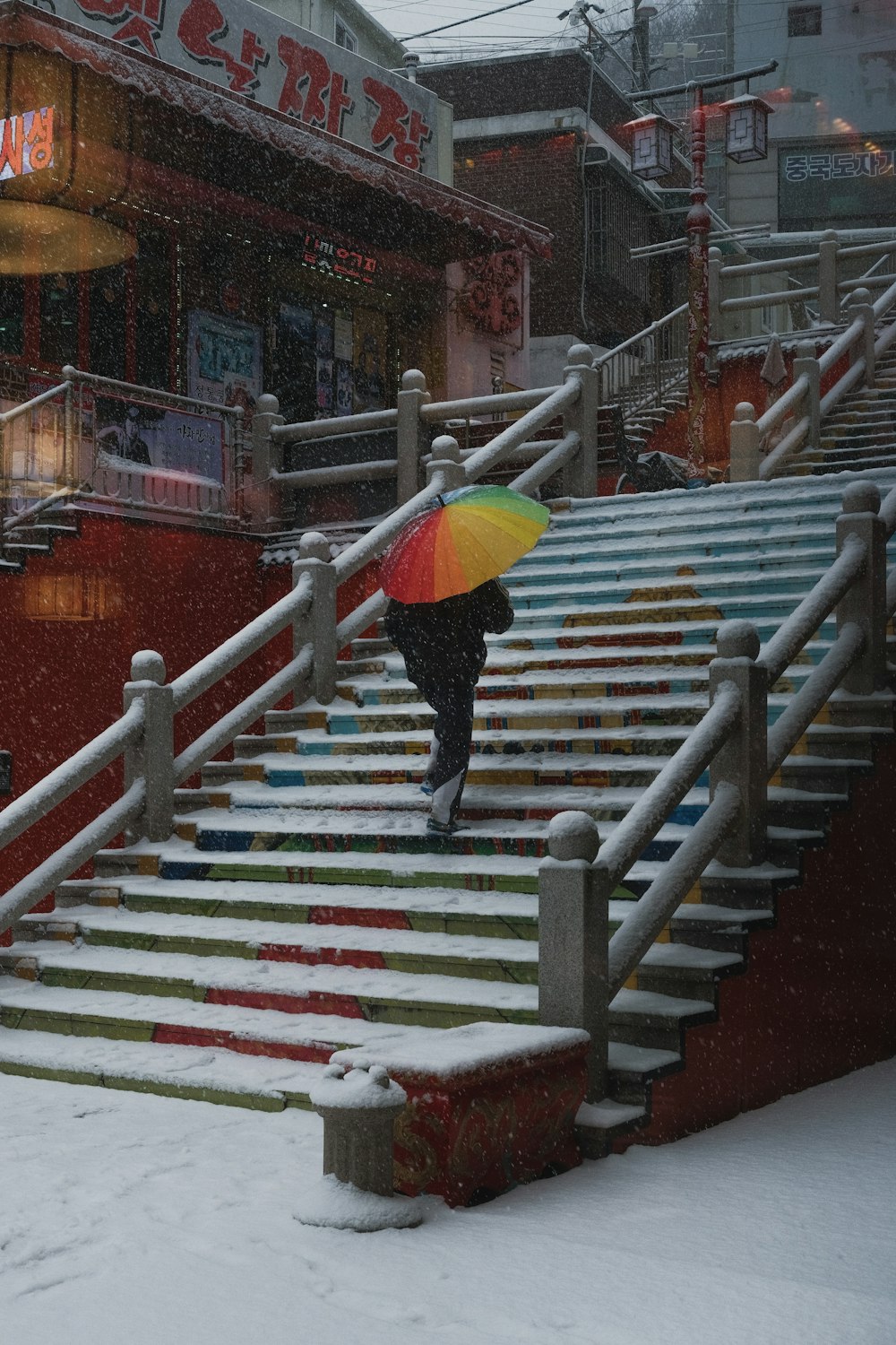 a person with an umbrella walking up some stairs