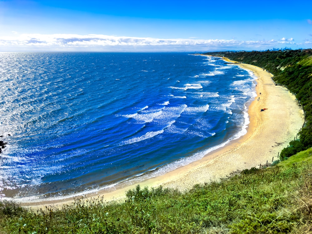 a view of a beach from a hill overlooking the ocean