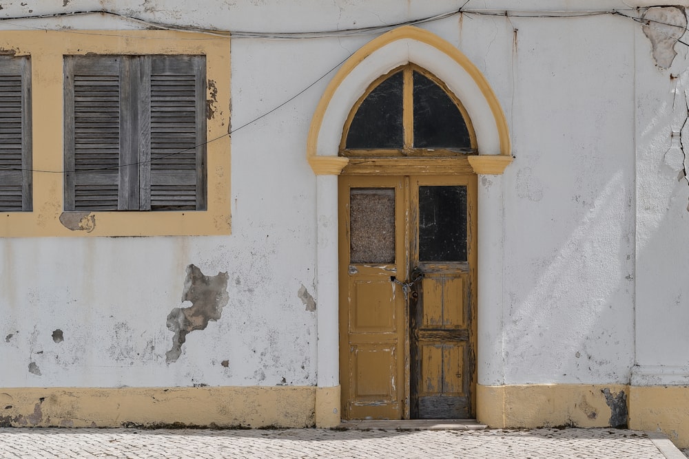 an old building with a yellow door and arched window