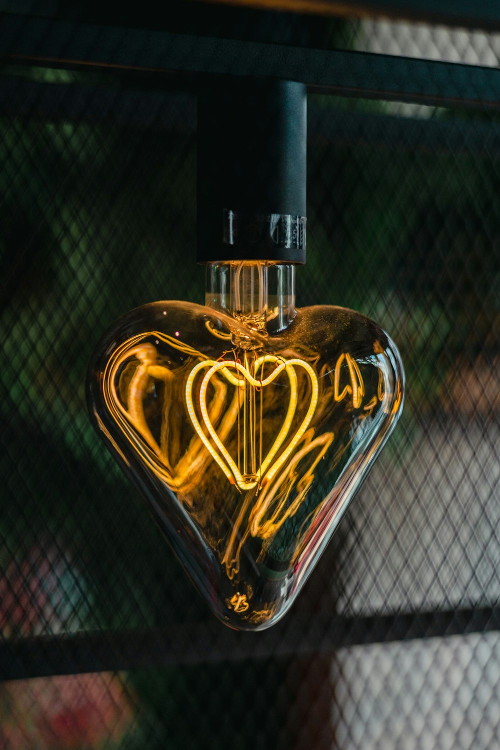 a heart shaped light bulb hanging from a wire