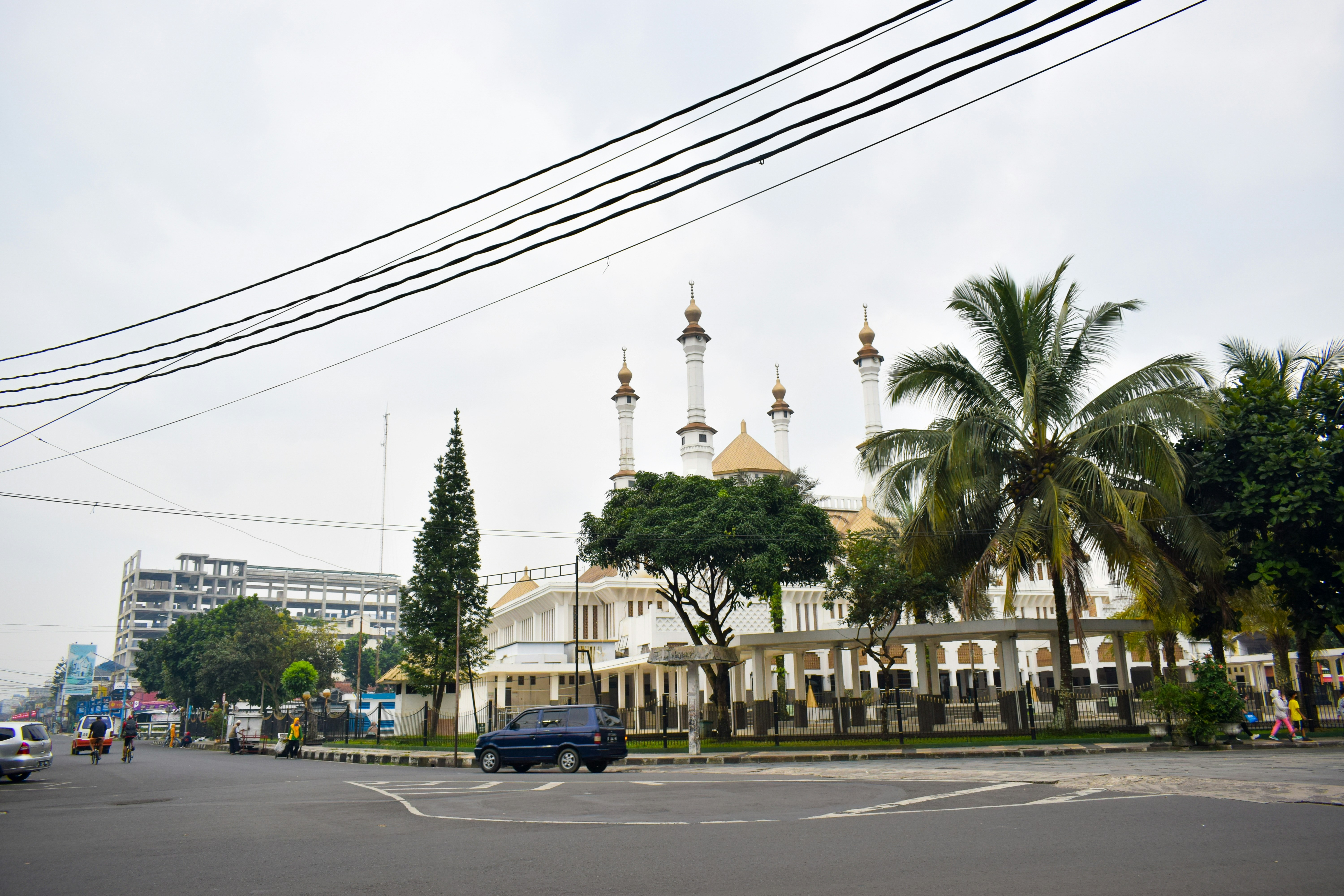 Un coche conduciendo por una calle junto a edificios altos