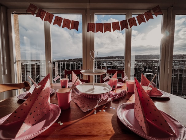 a wooden table topped with plates and cups