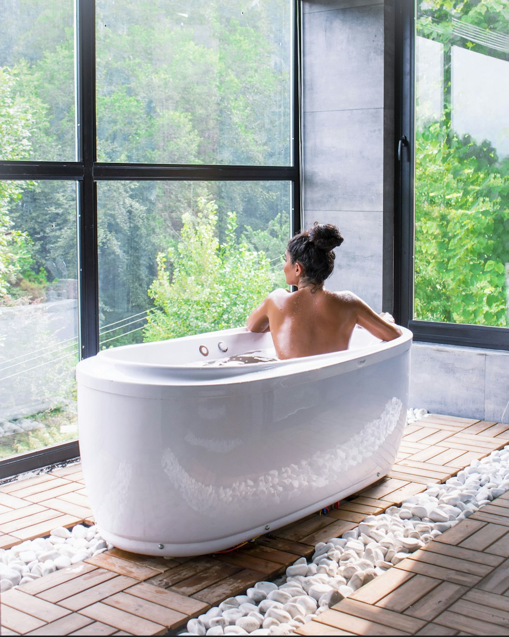 a woman sitting in a bathtub in front of a window