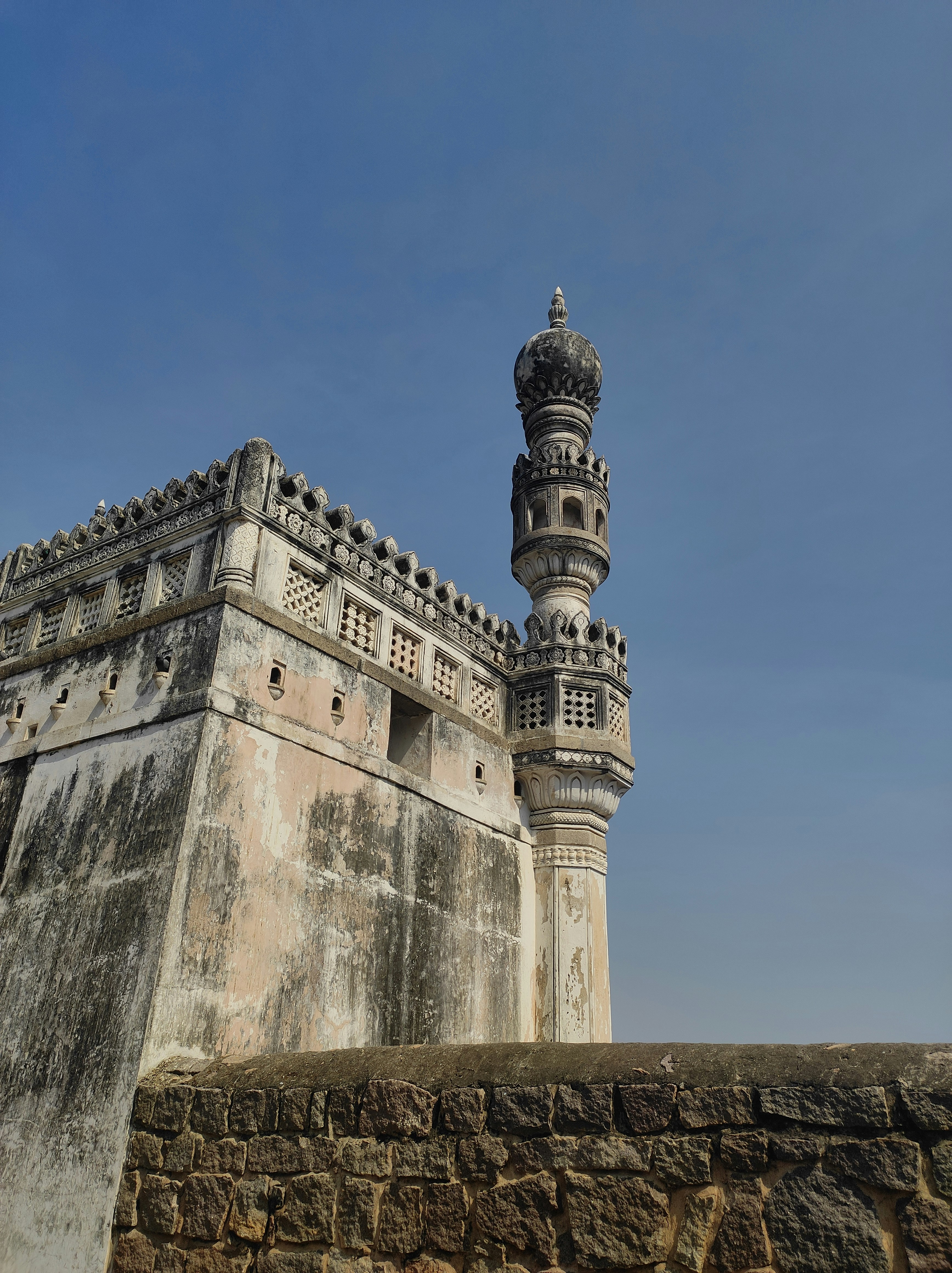 a tall tower sitting next to a stone wall