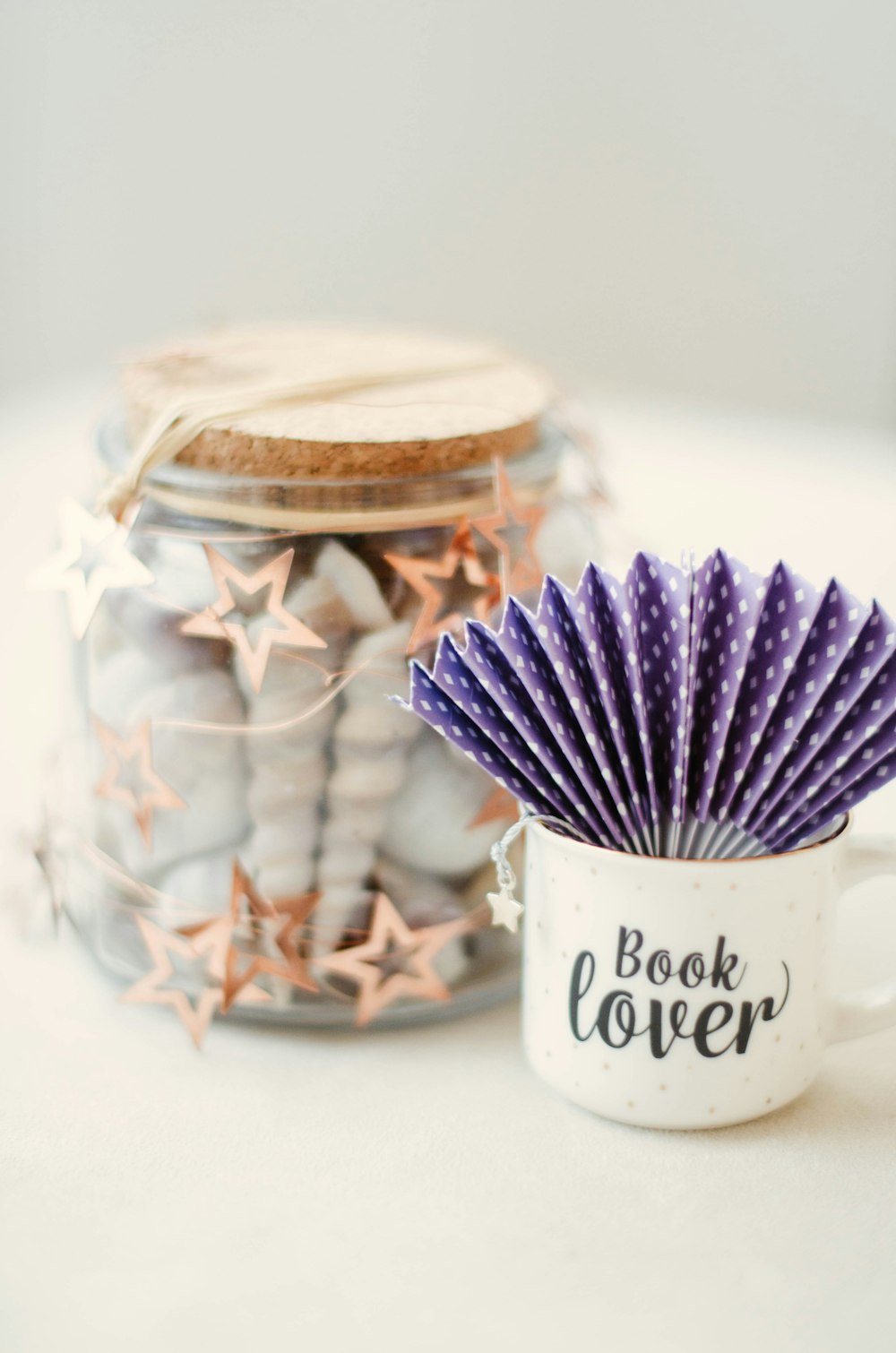 a mug with a star decoration next to a jar of cookies