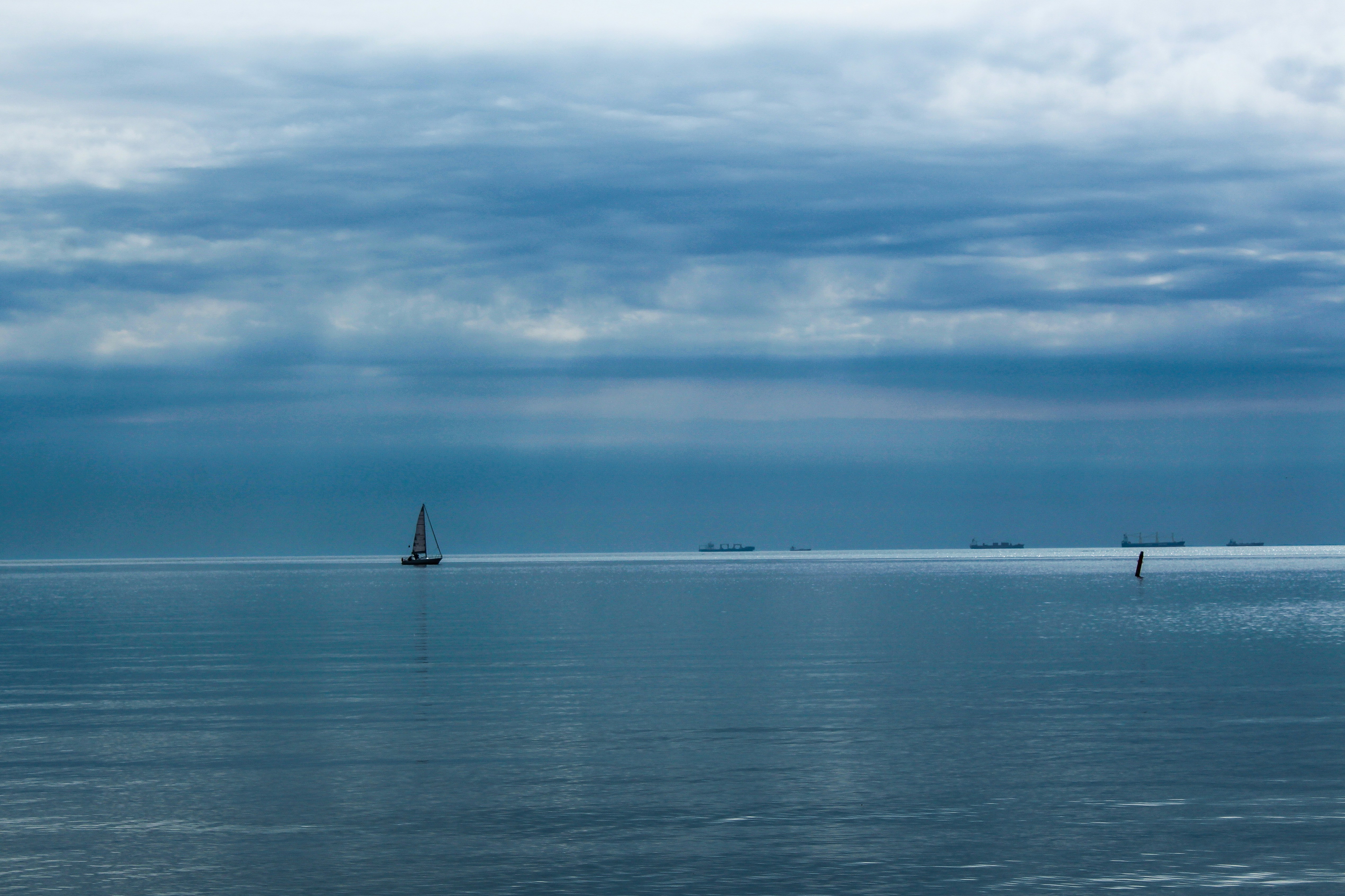 ein großes Gewässer mit einem Boot in der Ferne