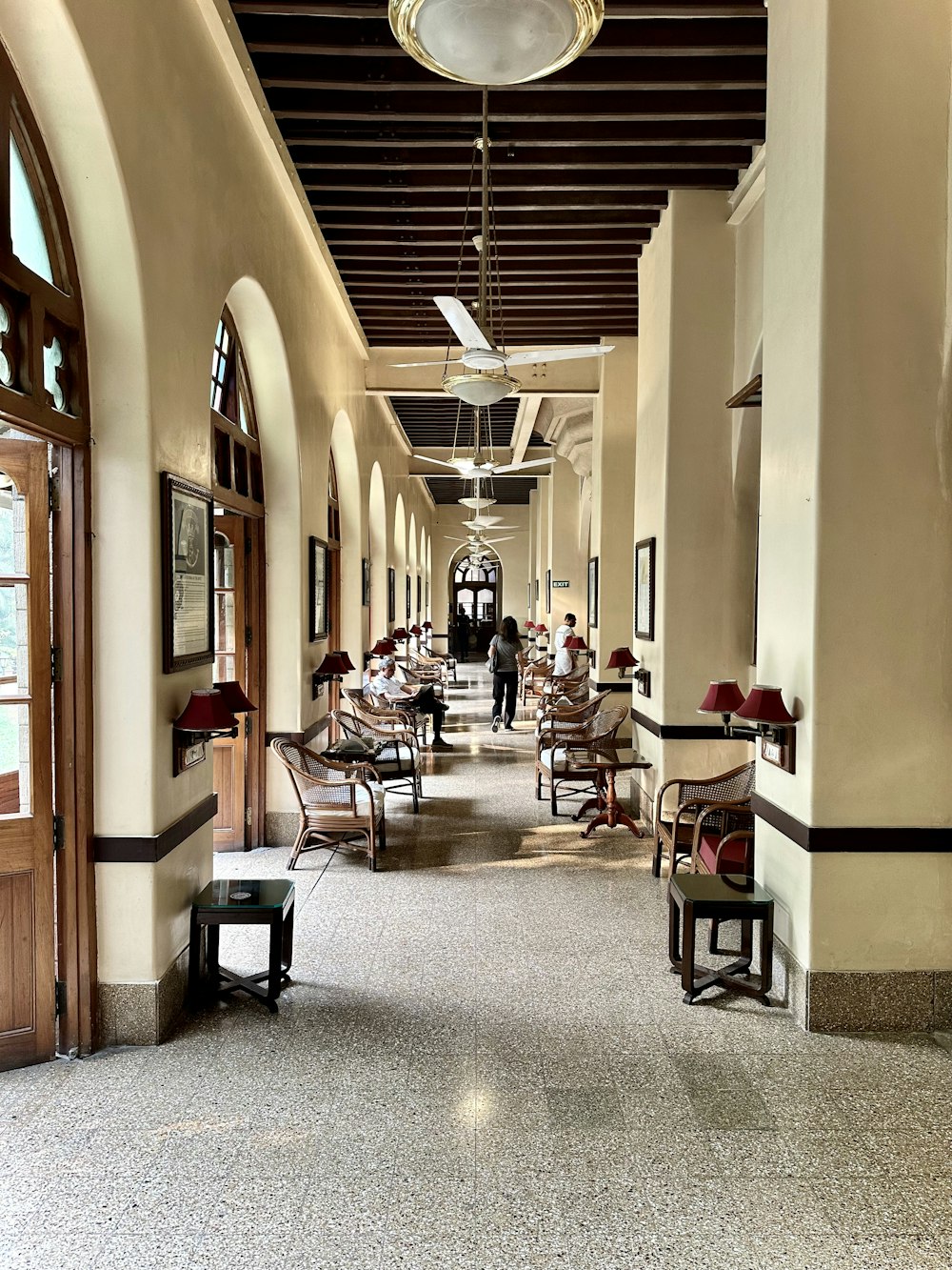 a long hallway with chairs and a ceiling fan