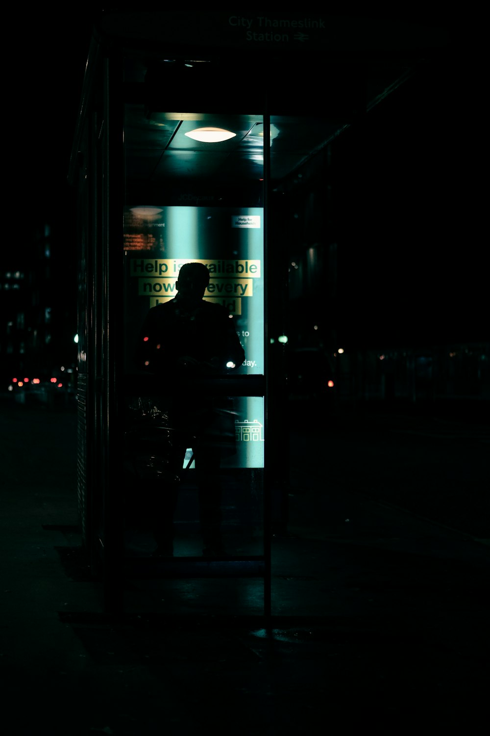 a person standing in a bus stop at night