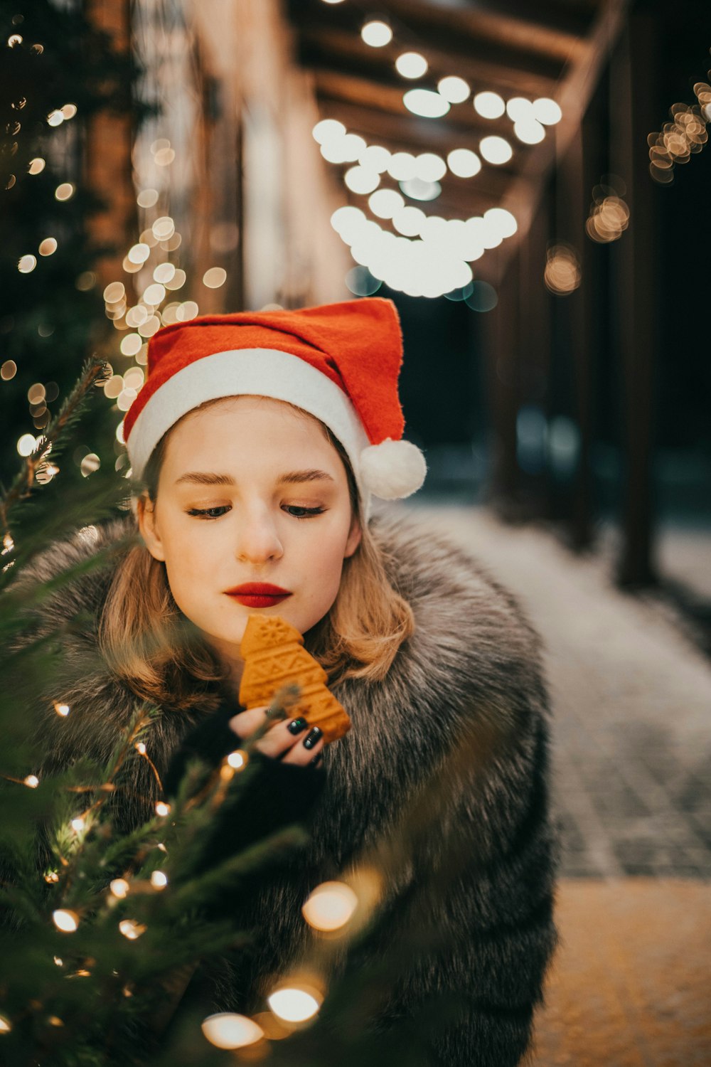 a girl in a santa hat eating a piece of food