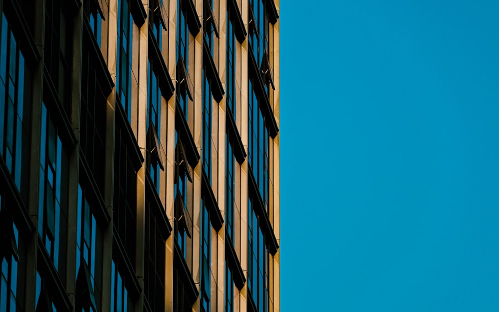 a tall building with lots of windows next to a blue sky