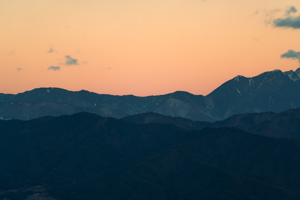 a plane flying over a mountain range at sunset