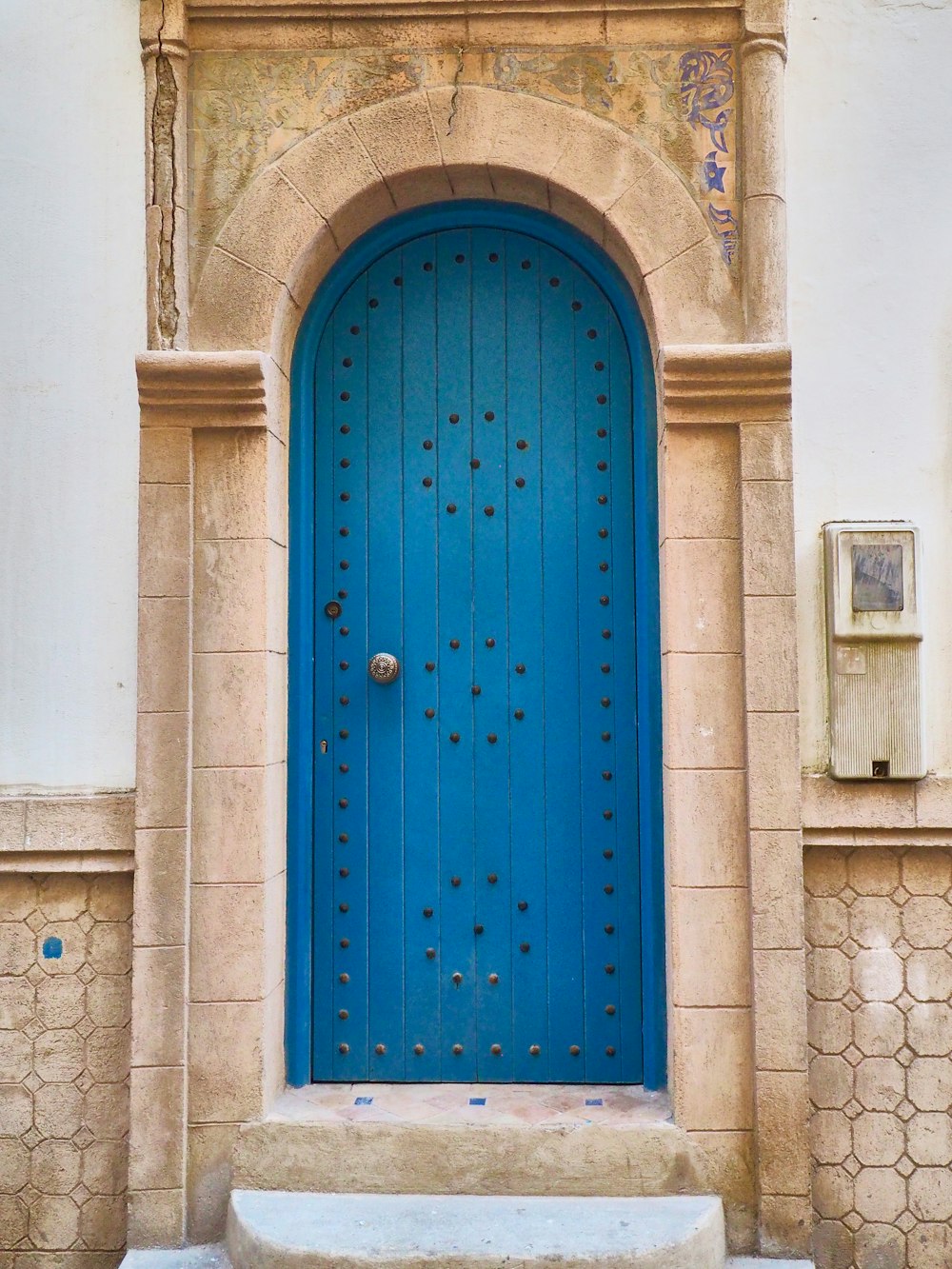 a blue door with a stone step in front of it