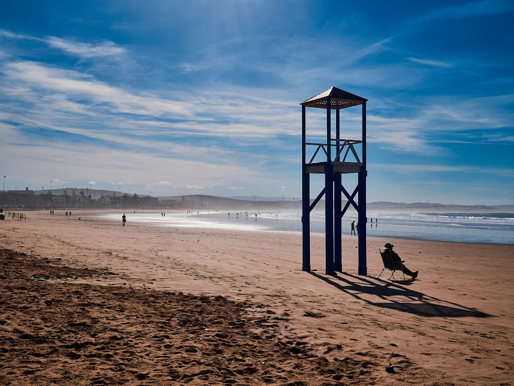 a lifeguard tower on a beach with people in the background