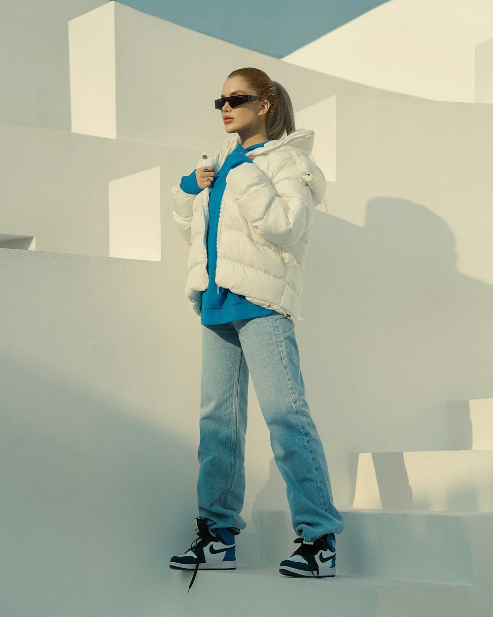 a woman in a white jacket and sunglasses