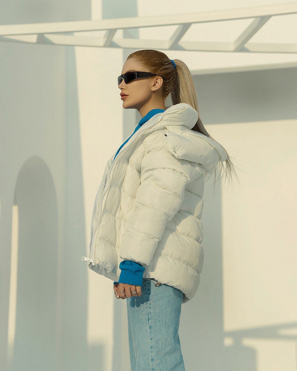 a woman in a white jacket and sunglasses